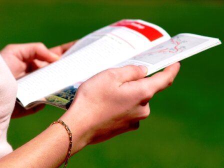 Woman's hands holding travel guide open