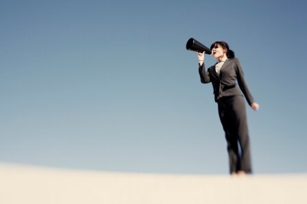 Woman in suit speaking into megaphone