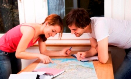 Man and woman smiling looking at map