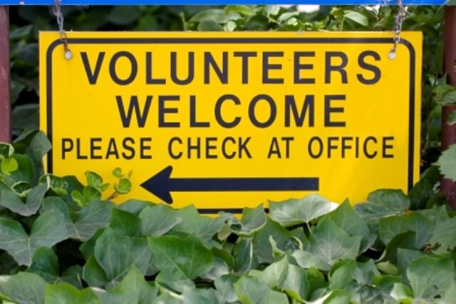 Sign reading "Volunteers Welcome" with arrow